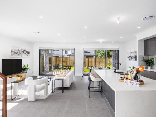 an open kitchen and living room with white furniture at 2024 Brand-new 5BR Comfort House in SunnybankHills in Brisbane