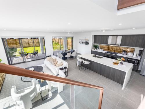 an open kitchen and living room with white furniture at 2024 Brand-new 5BR Comfort House in SunnybankHills in Brisbane
