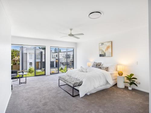 - une chambre blanche avec un lit et un canapé dans l'établissement 2024 Brand-new 5BR Comfort House in SunnybankHills, à Brisbane