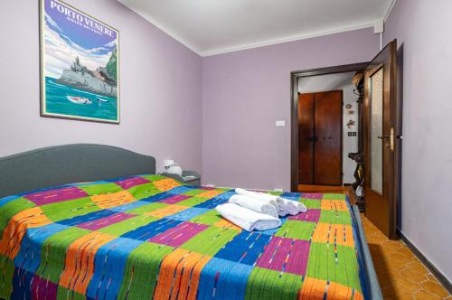 1 dormitorio con 1 cama colorida y toallas. en Ca' Du Beppino Portovenere Central Suite en Portovenere