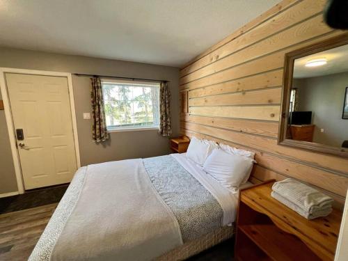 a bedroom with a large bed and a mirror at Alpenrose , hottub, Big Deck, Mountain Views in Golden