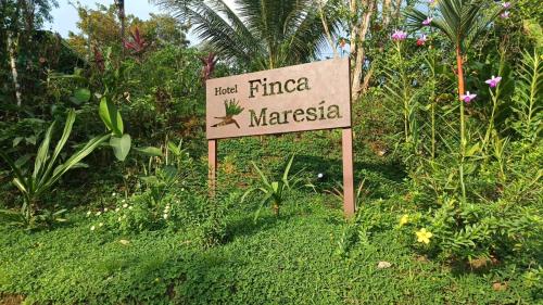 a sign in the grass in front of a garden at Hotel Finca Maresia in Drake