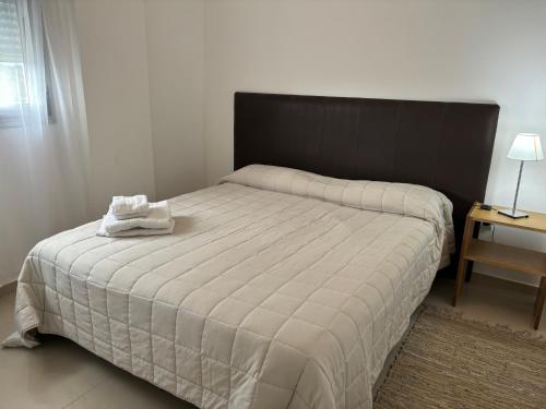 - une chambre avec un grand lit et une tête de lit noire dans l'établissement Departamento 6 piso con piscina, de 1 dormitorio, à Río Cuarto