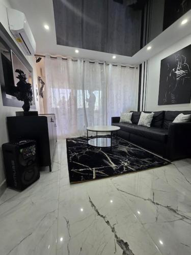 un salon avec un canapé et une table dans l'établissement Le Noir & Blanc Port Nature 4 Village Naturiste Cap d'Agde, au Cap d'Agde