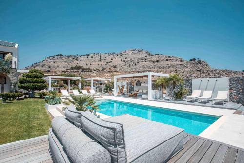 une maison avec une piscine et une montagne en arrière-plan dans l'établissement Oneiro Villa - Voted the best Villa in Rhodes, Greece!, à Pefki