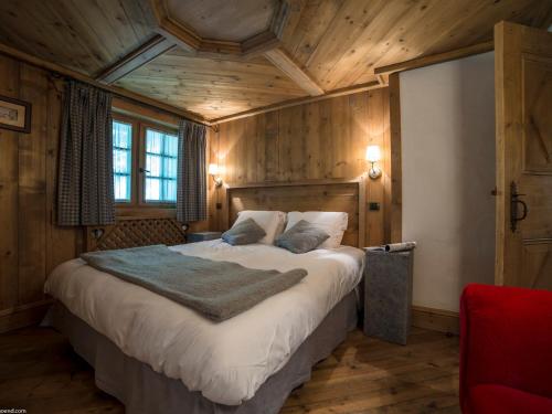 ein Schlafzimmer mit einem großen Bett in einem Zimmer mit Holzdecken in der Unterkunft Duplex de Charme à Courchevel 1850 - Capacité 10 Personnes, Centre-Ville - FR-1-575-29 in Courchevel