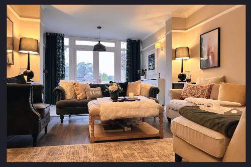 ein Wohnzimmer mit einem Sofa und einem Tisch in der Unterkunft The Richmond Retreat in New Malden