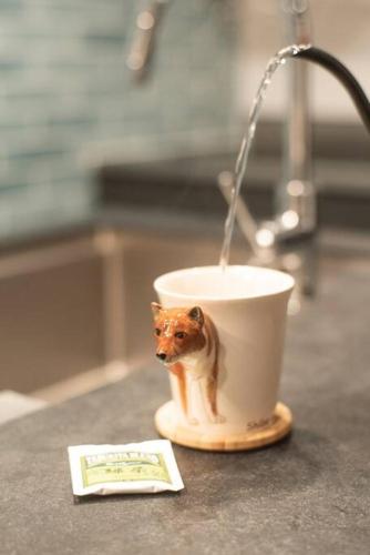 a cup with a dog on it sitting on a counter at Doggo伊豆　愛犬と過ごす最高の時間の為に造られた貸切宿。温泉、プライベートドッグランで最高の一時を。 in Ito