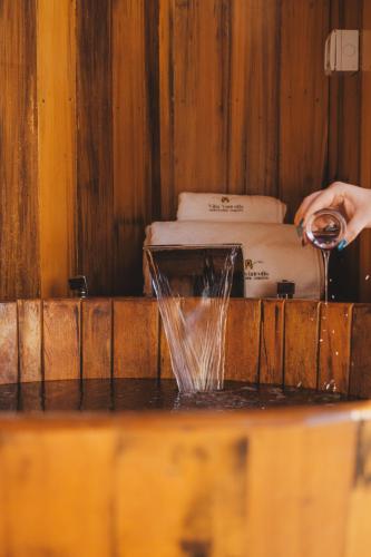 a person is pouring water into a bath tub at Villa Vinicolla - Refúgio & Vinícola Boutique com Degustações in Bento Gonçalves