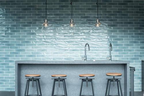 a kitchen with a counter with four bar stools at Doggo伊豆　愛犬と過ごす最高の時間の為に造られた貸切宿。温泉、プライベートドッグランで最高の一時を。 in Ito