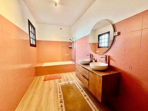 un bagno con due lavandini e uno specchio di Maison de village vue mer et montagne a Sari Solenzara