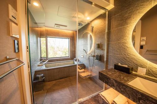 a bathroom with a glass shower and a sink at Doggo伊豆　愛犬と過ごす最高の時間の為に造られた貸切宿。温泉、プライベートドッグランで最高の一時を。 in Ito