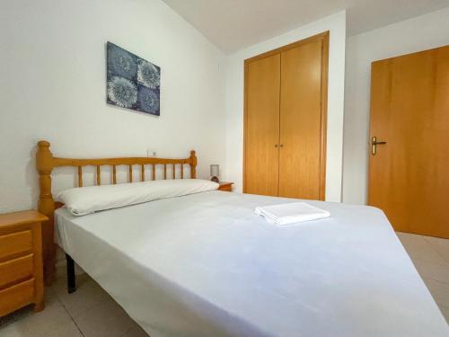 オロペサ・デル・マールにあるApartamentos Entreplayas 3000のベッドルーム(白い大型ベッド1台、木製クローゼット付)
