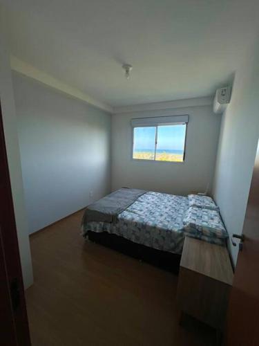 a bedroom with a bed in a room with a window at Vista Mar Buraquinho in Lauro de Freitas