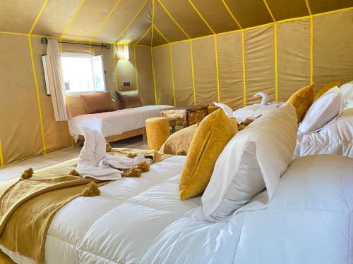 a room with a bunch of beds in a tent at Explore merzouga luxury camp in Merzouga