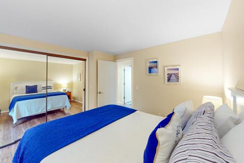 1 dormitorio con 1 cama grande y espejo en South Cape Escape, en Mashpee