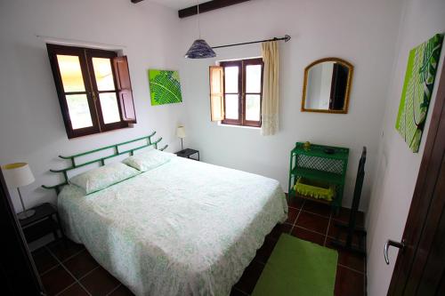 a bedroom with a white bed and two windows at Cidrão dos Brejos in Santiago do Cacém