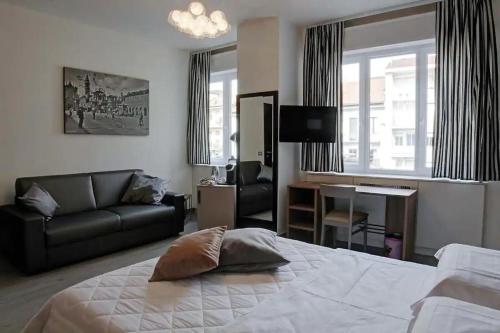 1 dormitorio con cama, sofá y escritorio en Arsenale Turin Rooms, en Turín