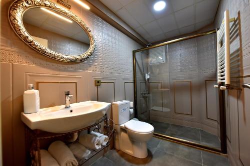 a bathroom with a sink and a toilet and a mirror at Adakale Butik in Çanakkale