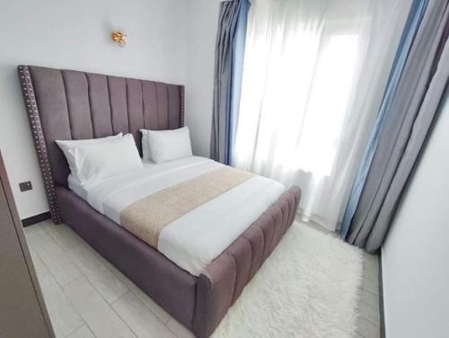 1 dormitorio con 1 cama grande y ventana grande en Staroot 2 bedroom staycation in kilimani, en Nairobi