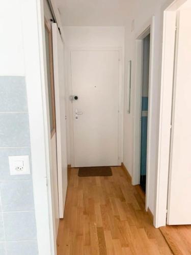 瓦洛爾的住宿－Chambre Privé，走廊上设有白色门,铺有木地板
