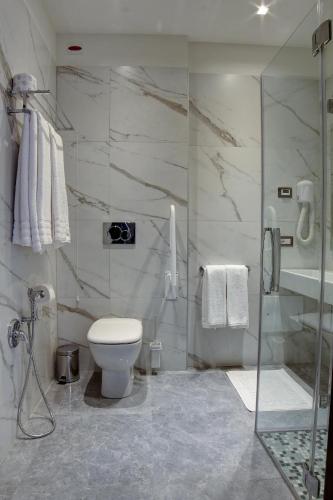 a bathroom with a toilet and a glass shower at Arsenale Turin Rooms in Turin
