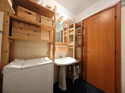 a small bathroom with a sink and a washing machine at Hostdomus - Wood Apartment in Cesana Torinese