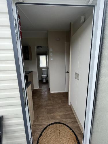 a hallway with a door open to a room with a toilet at Premium location - Sleeps 6 - Caravan on The Lakes in Mablethorpe