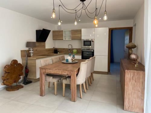 a kitchen and dining room with a wooden table and chairs at Casa Laura in Cervione
