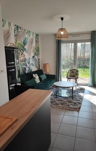 a living room with a couch and a table at La Maison Olivia in La Rivière-Saint-Sauveur