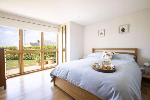 a bedroom with a bed with a tray of food on it at Sandbar in Saint Just in Roseland
