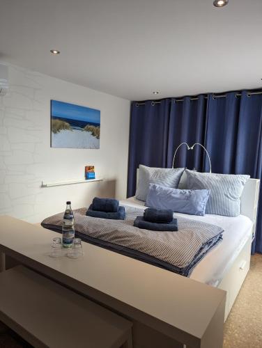 a bedroom with a large bed with blue curtains at Ferienhaus am See mit Ruderboot in Mustin
