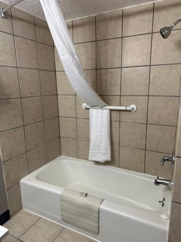 a bathroom with a tub and a shower curtain at Baymont by Wyndham Deming in Deming