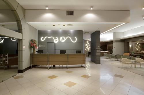 a lobby with a waiting area with chairs and tables at Araucaria Plaza in Ribeirão Preto