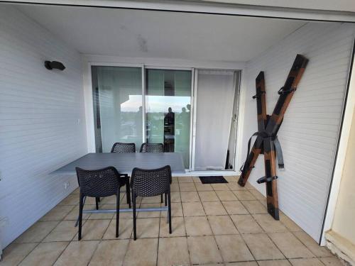 une salle à manger avec une table et des chaises sur un patio dans l'établissement L'éden Port Nature 5 Village Naturiste Cap d'Agde, au Cap d'Agde