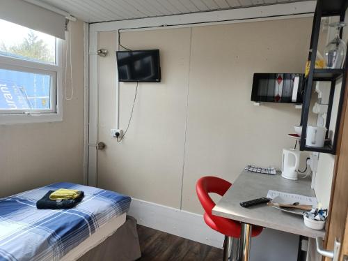a room with a bed and a table and a window at The Townhouse Self Catering in Dumfries