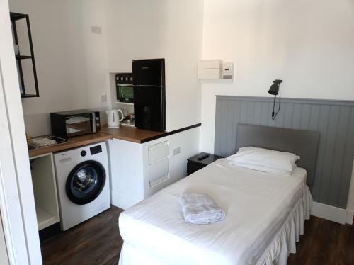 a bedroom with a bed and a washing machine at The Townhouse Self Catering in Dumfries