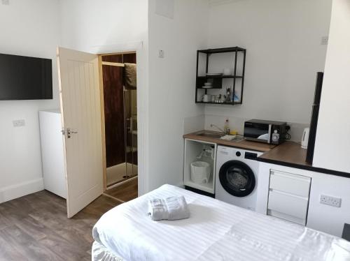 a room with a bed and a washing machine at The Townhouse Self Catering in Dumfries