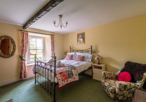 a bedroom with a bed and a chair at Rose Cottage in Richmond