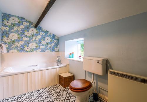 a bathroom with a toilet and a bath tub at Rose Cottage in Richmond