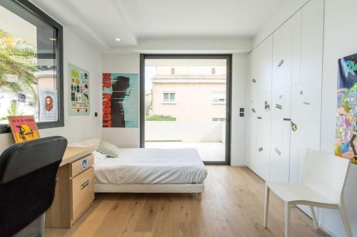 une chambre avec un lit, un bureau et une fenêtre dans l'établissement Superbe villa moderne avec piscine à Marseille - Villa Marseilleveyre, à Marseille