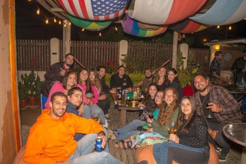 a group of people sitting around a table with drinks at Hostal Kuyen in Pichilemu