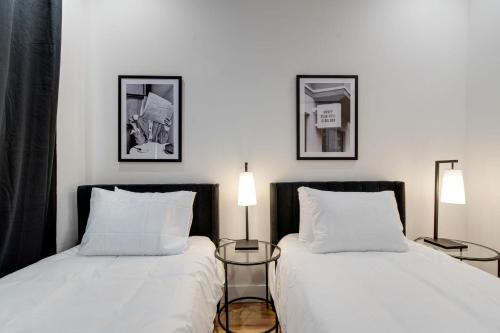 - 2 lits installés l'un à côté de l'autre dans une chambre dans l'établissement Modern Monroe - Private Rooftop - Minutes to Broadway, à Nashville
