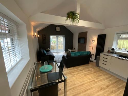 a living room with a couch and a table at The Court Yard Apartment in Cheddar