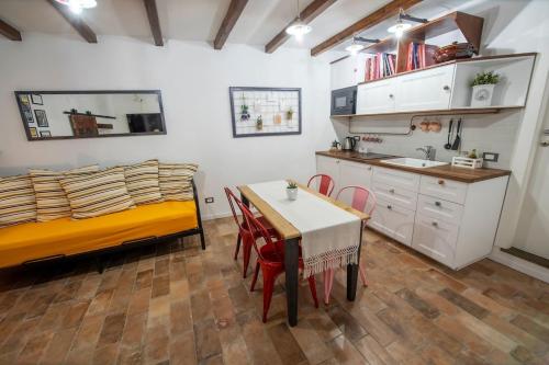 een slaapkamer met een tafel en een bed en een keuken bij Vicolo39 La casa a due passi dal Lago in Trevignano Romano