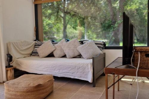 une chambre avec un lit avec des oreillers et une fenêtre dans l'établissement Villa Bergerie Baracco Argia, piscine, maquis et tradition corse pour 6 personnes, à Barbaggio