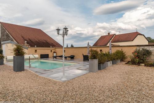 une maison avec une piscine dans une cour dans l'établissement La Forêt de Velours, à Bourberain