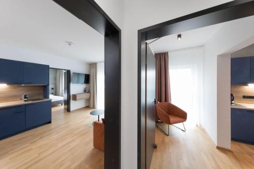 una cucina e un soggiorno con armadi blu e una sedia di Brera Serviced Apartments Singen a Singen