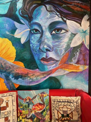 a mural of a woman with flowers on the wall at Hostal Kuyen in Pichilemu