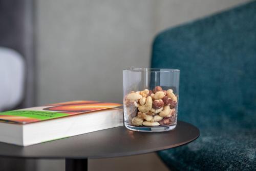 a glass jar of nuts on a table next to a book at Brera Serviced Apartments Singen in Singen
